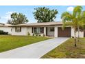 Inviting single-story home features a long driveway and fresh landscaping at 416 Graham Dr, Clearwater, FL 33765