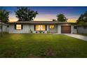 Charming single-story home with lush green lawn, great curb appeal at dusk at 416 Graham Dr, Clearwater, FL 33765