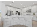 A bright, modern kitchen features white cabinets, stainless steel appliances, and a large center island at 4423 Pond Brook Ct, Bradenton, FL 34211