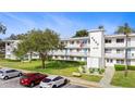 Well-maintained condo building featuring assigned parking, landscaped lawn, and mature trees at 8533 110Th St # 207, Seminole, FL 33772