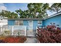 Close-up of a blue home's front entrance, highlighting the white picket fence and front door at 9101 86Th Ave, Seminole, FL 33777