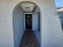 Inviting home entrance with an arched doorway and a decorative tile walkway at 11715 Salmon Dr, Port Richey, FL 34668