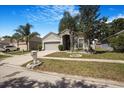 Inviting single-Gathering home with a lush front yard, palm trees, and a two-car garage adding to the neighborhood's charm at 13215 Beechberry Dr, Riverview, FL 33579