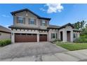 Elegant two-story home featuring a tile roof, stone accents, and a spacious three-car garage at 14421 Swiss Bridge Dr, Lithia, FL 33547