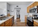 A kitchen with stainless steel appliances, wooden cabinets, and views to the rest of the house at 1601 Fluorshire Dr, Brandon, FL 33511