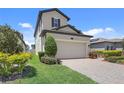 Two-story home featuring a paved driveway leading to an attached two-car garage and landscaped yard at 1949 Parterre Ave, Lutz, FL 33558