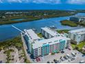 Aerial view of condos with a pool and a dock, nestled in a lush landscape with beautiful water views at 19531 Gulf Blvd # 604, Indian Shores, FL 33785