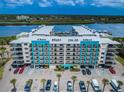 Stunning exterior shot of the condos showcasing the manicured landscape, parking, and the building's colorful accents at 19531 Gulf Blvd # 604, Indian Shores, FL 33785