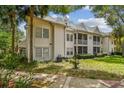 Exterior view of the rear of the townhome, with a view of the lawn and patio area at 3261 Haviland Ct # 303, Palm Harbor, FL 34684