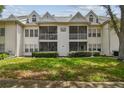 White condo featuring screened balconies, neat green lawn, and well-maintained shrubbery at 3261 Haviland Ct # 303, Palm Harbor, FL 34684