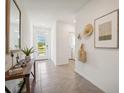 Inviting hallway with neutral tile floors and stylish decor leading to the home's bright interior at 32708 Winterwood Blvd, Wesley Chapel, FL 33543