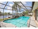 Sparkling screened-in pool overlooking the waterfront; outdoor living at its finest at 5616 Riddle Rd, Holiday, FL 34690