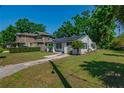 Landscaped lawn featuring a white home with solar panels and a brick pathway at 701 W Idlewild Ave, Tampa, FL 33604