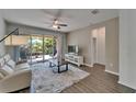 Cozy living room with wood-look tile floors and sliding glass doors leading to the patio at 7417 Sungold Meadow Ct, Apollo Beach, FL 33572