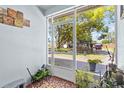Cozy screened porch offering a serene view of the neighborhood street and mature trees at 7747 90Th N Way, Seminole, FL 33777