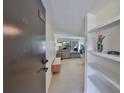Condo entryway with white-tiled floor, door to unit 202 and shelf with decorative items at 880 S Village N Dr # 202, St Petersburg, FL 33716