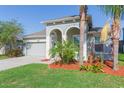 Beautiful single-story home showcasing an attached two-car garage, arched entryway, and landscaped front yard at 13334 Palmera Vista Dr, Riverview, FL 33579