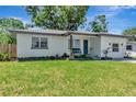 Charming one-story home with fresh exterior paint, well-maintained landscaping, and a vibrant blue front door at 1545 Illinois Rd, Clearwater, FL 33756