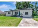 Charming one-story home with fresh exterior paint, well-maintained landscaping, and a vibrant blue front door at 1545 Illinois Rd, Clearwater, FL 33756