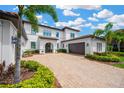 Well manicured two story home with lush landscaping and a paver driveway at 16419 Chapman Crossing Dr, Lithia, FL 33547
