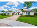 Landscaped two-story home featuring a tile roof, paver driveway, and a 3 car garage at 16419 Chapman Crossing Dr, Lithia, FL 33547