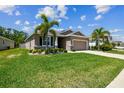 Beautiful home featuring lush green grass, a well-maintained lawn and landscaped flowerbeds at 16625 Goose Ribbon Pl, Wimauma, FL 33598