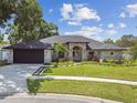 Charming single-story home with a well-manicured lawn and beautiful landscaping at 1727 Woodpond Way, Lutz, FL 33559
