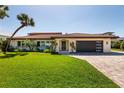 Beautiful one story waterfront home with lush green grass and manicured landscaping at 2096 Tanglewood Ne Way, St Petersburg, FL 33702