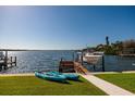 Beautiful waterfront view with a boat lift, two kayaks, and well maintained grassy area at 2096 Tanglewood Ne Way, St Petersburg, FL 33702
