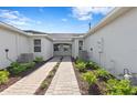Rear view of home showing walkway and air conditioning units at 27148 Capri Shores Cir, Englewood, FL 34223