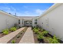 The property features a paver walkway, well maintained landscaping, and neutral color palette at 27156 Capri Shores Cir, Englewood, FL 34223