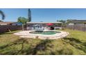 Backyard with pool area featuring an in-ground kidney-shaped pool, patio furniture, and partial fencing at 3066 19Th Sw Pl, Largo, FL 33774