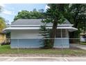Side exterior view of light blue house, accented by lush greenery and a secure chain-link fence at 3409 N 10Th St, Tampa, FL 33605