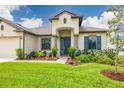Beautifully landscaped front yard showcasing the home's architecture, including a welcoming entryway and well-maintained lawn at 3503 Gaviota Dr, Sun City Center, FL 33573
