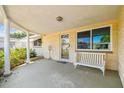 Welcoming front porch with a bench, decorative columns, and a stylish entrance door at 3514 Truman Dr, Holiday, FL 34691
