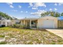 Inviting single-story home featuring a cozy front porch and well-kept lawn at 3514 Truman Dr, Holiday, FL 34691