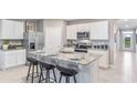 Bright kitchen with an island, white cabinets, granite countertops, and stainless steel appliances at 35687 Lockman Way, Zephyrhills, FL 33541