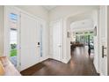 Inviting entryway with hardwood floors, a transom window, and an arched doorway to the living area at 4405 Barletta Ct, Wesley Chapel, FL 33543