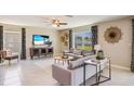 Bright living room with neutral tones, stylish furnishings, and a ceiling fan at 5527 Warrington Town Path, Wesley Chapel, FL 33545