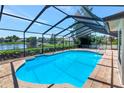 Enclosed pool with a screened enclosure and a serene lake view at 6056 Fall River Dr, New Port Richey, FL 34655