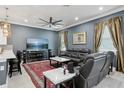 Cozy living room with a ceiling fan, plush seating, a large television and an eye-catching red rug at 714 S Lois Ave, Tampa, FL 33609