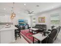 Open-concept living room features a comfortable leather sectional, large TV, and bar seating connected to the kitchen at 714 S Lois Ave, Tampa, FL 33609