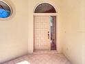 Close-up of front door with decorative window and tiled entryway at 9308 Fairway Lakes Ct, Tampa, FL 33647