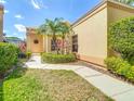 Inviting home entrance with manicured garden, walkway, and unique round window at 9308 Fairway Lakes Ct, Tampa, FL 33647