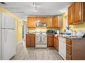 Well-lit kitchen with wood cabinetry and white appliances at 1019 Goshen Rd, Tarpon Springs, FL 34689
