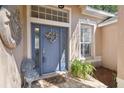Close-up of a blue front door with decorative wreath, sidelights, and tiled entrance at 12523 Riverglen Dr, Riverview, FL 33569