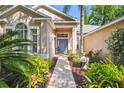 Inviting front entrance with a stone pathway and lush tropical plants at 12523 Riverglen Dr, Riverview, FL 33569