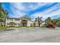 Apartment building with parking area, mature landscaping, and private balconies at 130 Sabal Ct # C, Oldsmar, FL 34677