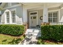 Charming entrance with brick accents, white trim, and meticulously maintained landscaping at 14705 Canopy Dr, Tampa, FL 33626
