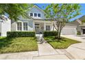 Inviting two-story home with a manicured lawn, charming front porch, and attached garage at 14705 Canopy Dr, Tampa, FL 33626